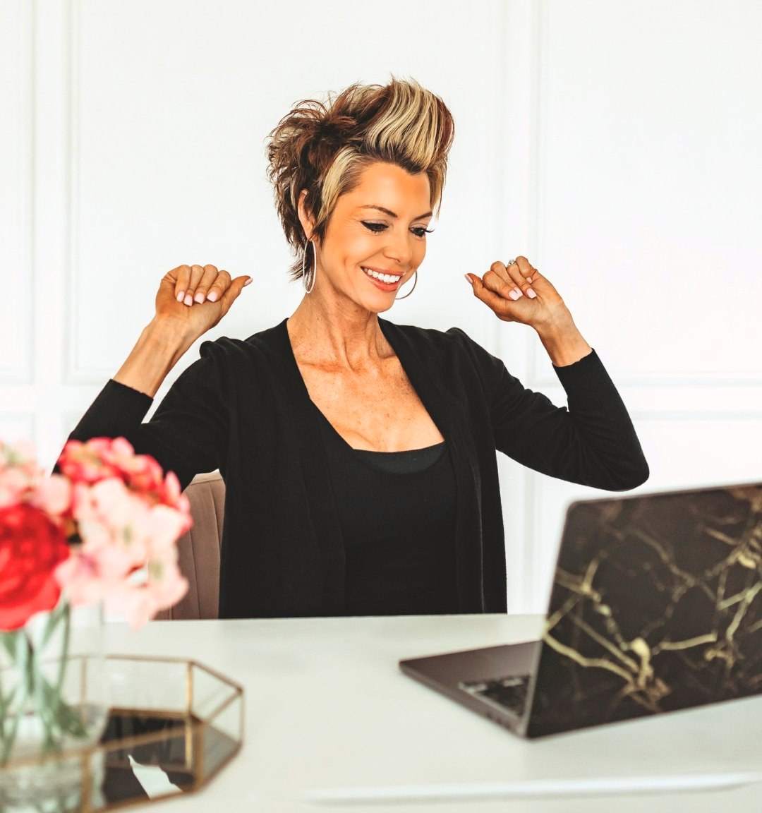 Stephanie Lindamood celebrating at her desk in front of her laptop